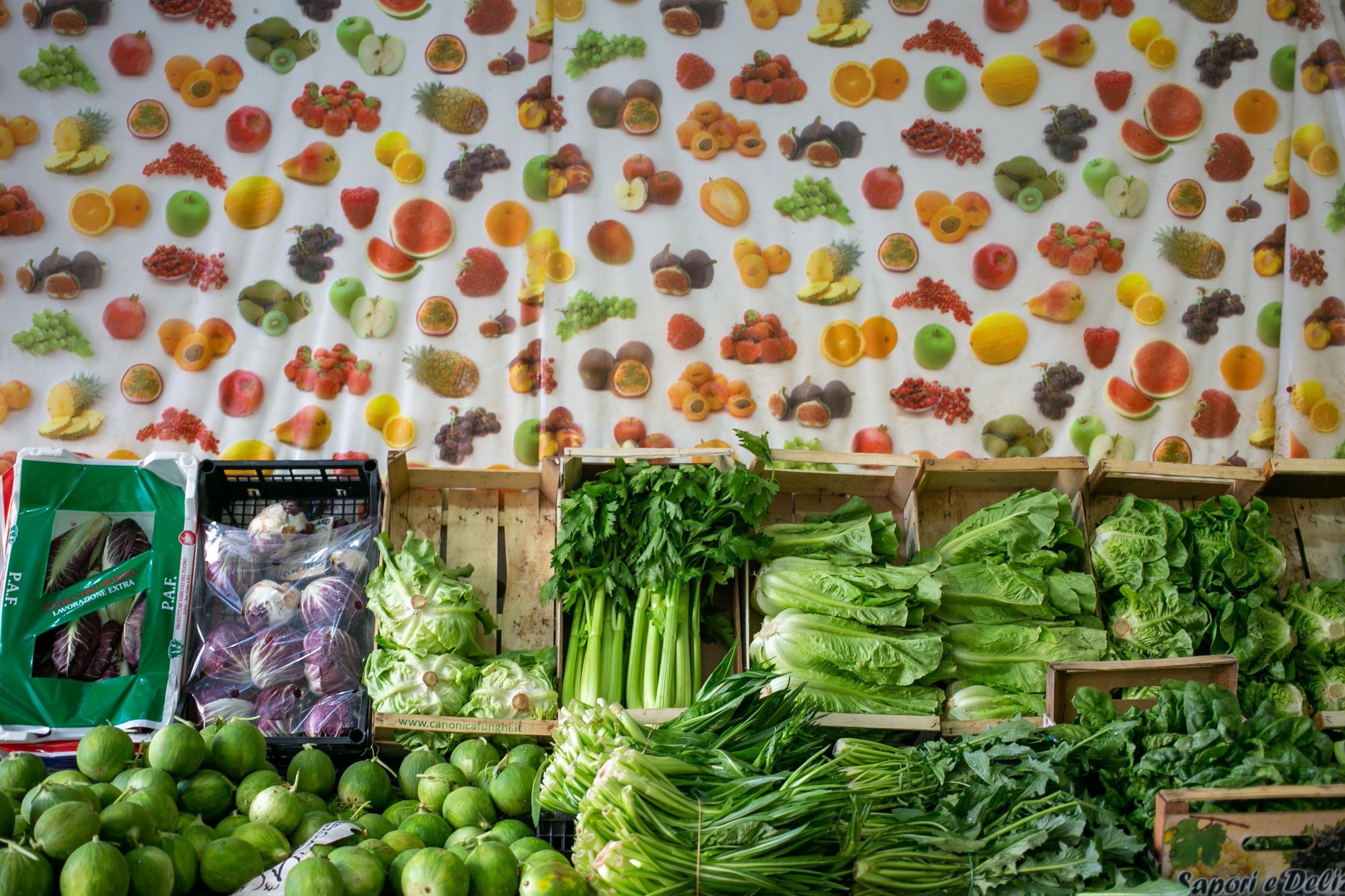 Fresh vegetables and produce arranged in wooden crates at a market display.
