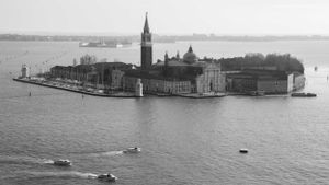 Aerial view of Venice's San Giorgio Maggiore island with its iconic church and bell tower surrounded by water.