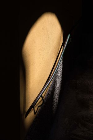 Dramatic shadow and light on a handrail in a dark corridor.