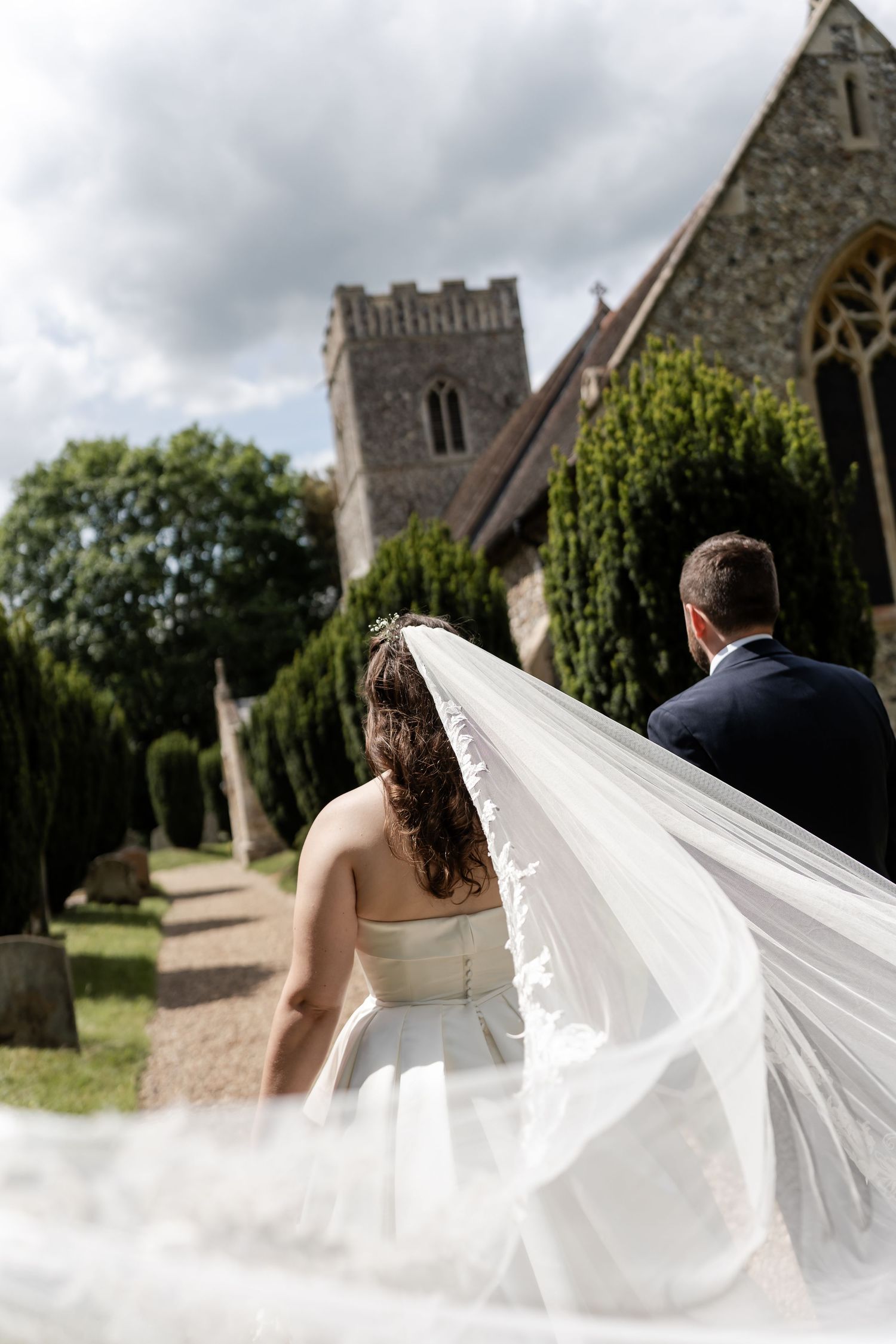 Beautiful candid wedding veil moment, walking to church in Suffolk, ahead of their Wedding in France. candid, authentic and relaxed photos