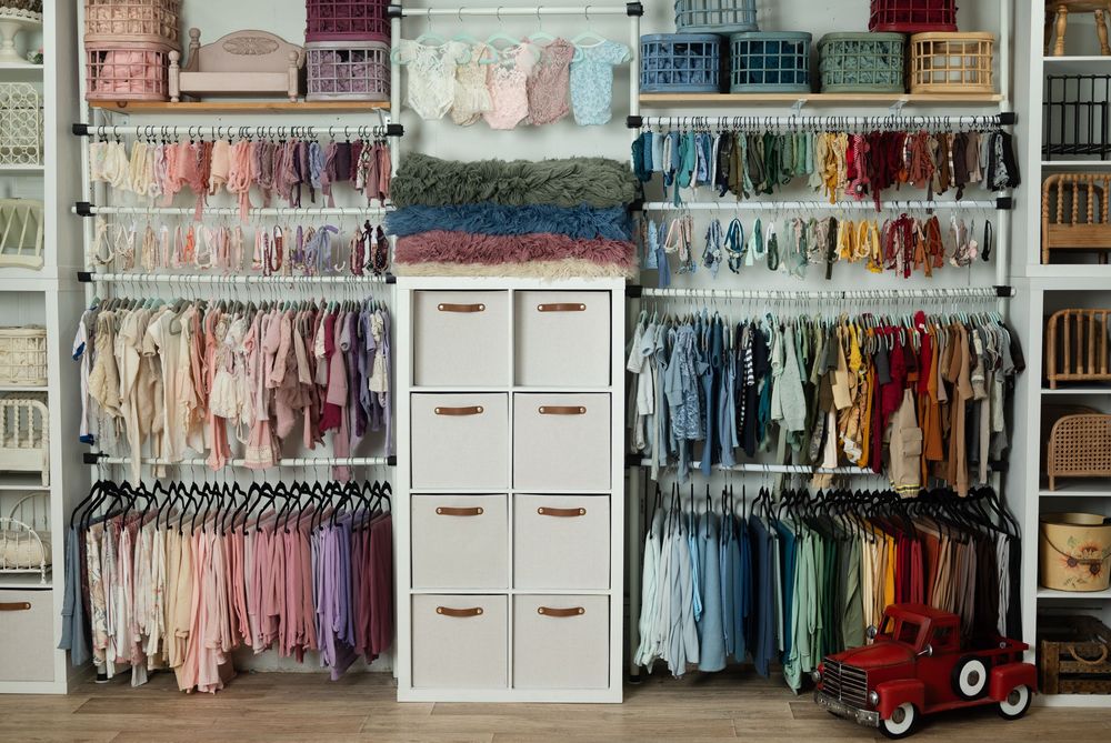 Rows of clothing arranged by color and white storage units for baby and children's apparel. Marion Indiana