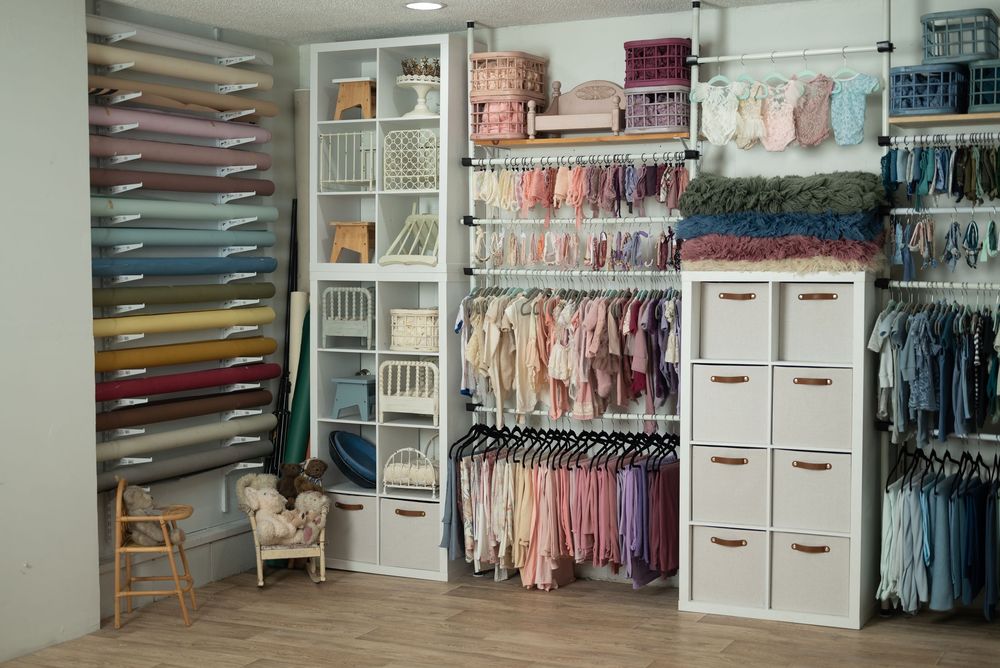 Rows of clothing arranged by color and white storage units for baby and children's apparel. Huntington Indiana