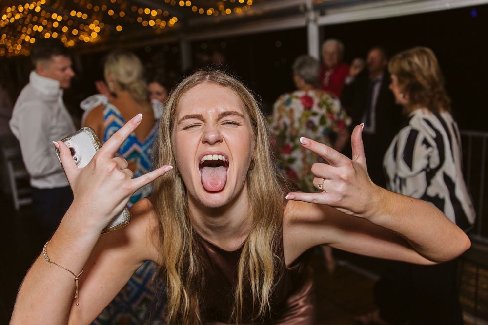 Guests enjoying a lively celebration on the dance floor under warm lighting.