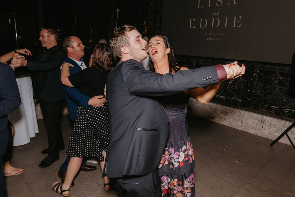 Wedding guests dance and celebrate during the evening reception party.