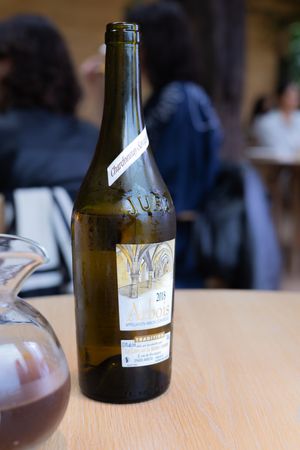Vintage wine bottle with label partially visible on wooden table.