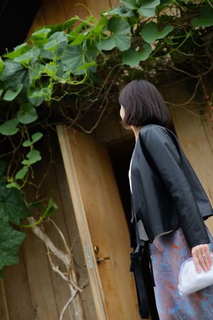 Customer entering wooden doorway decorated with climbing green vines.