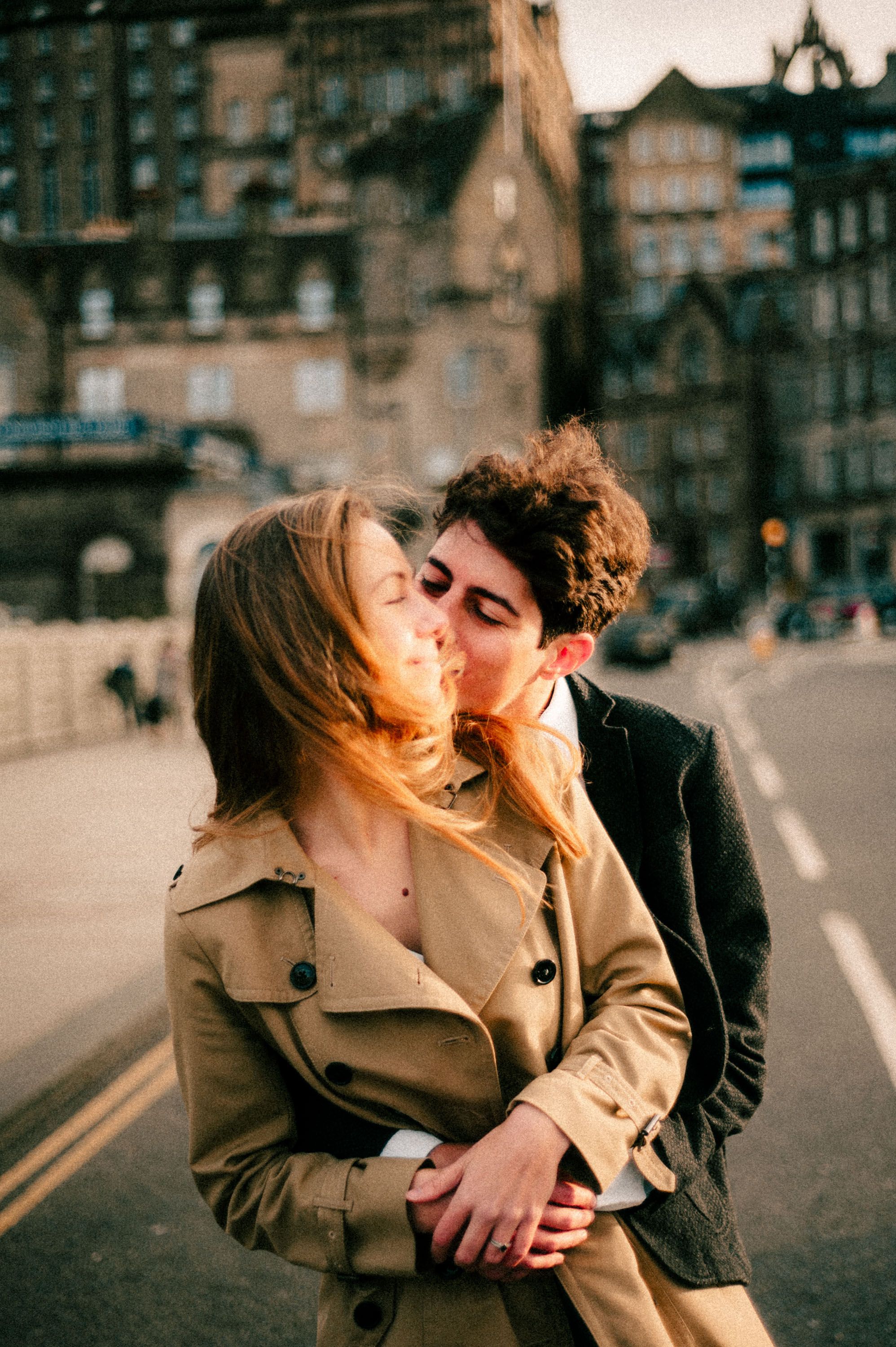 A tender romantic moment shared on an Edinburgh street with classic architecture.
