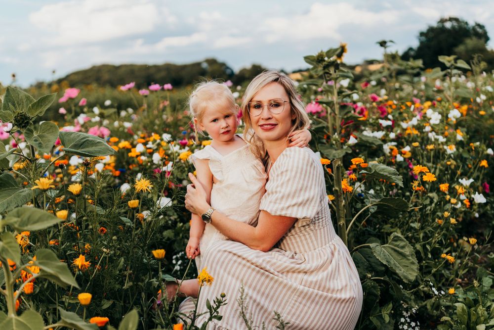 People embrace in a beautiful garden of colorful wildflowers and zinnias on a sunny summer day.  Family Photoshoot. Writtle Sunflowers.