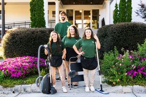 Group photo session outside building with landscaped garden.