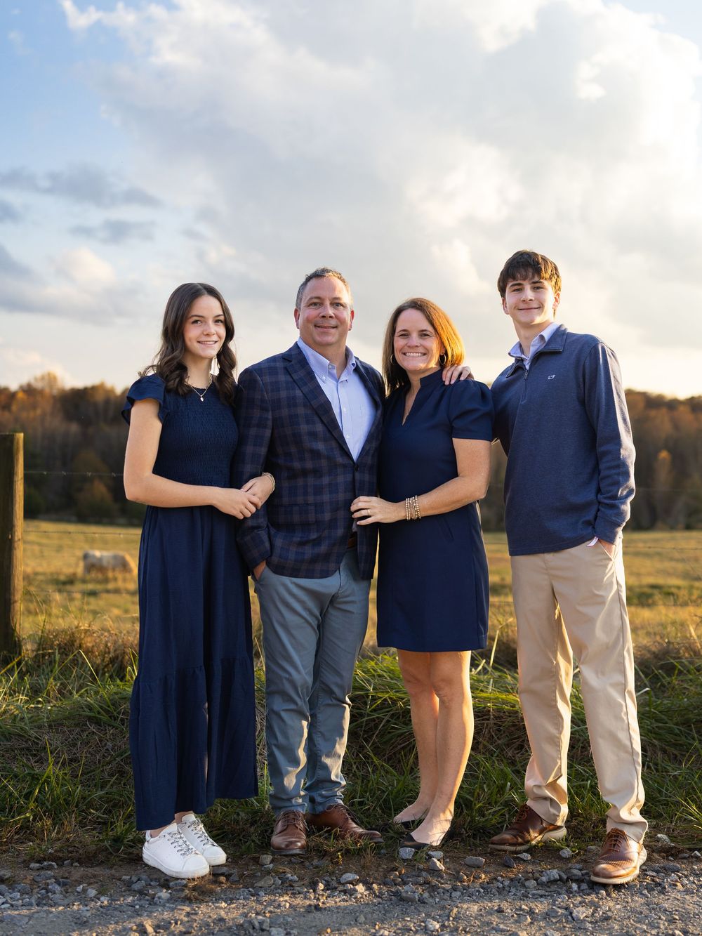 Family group portrait outdoors wearing coordinated navy and khaki outfits.