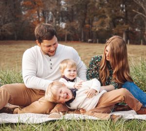 Family relaxing together on autumn grass during an outdoor photo session.