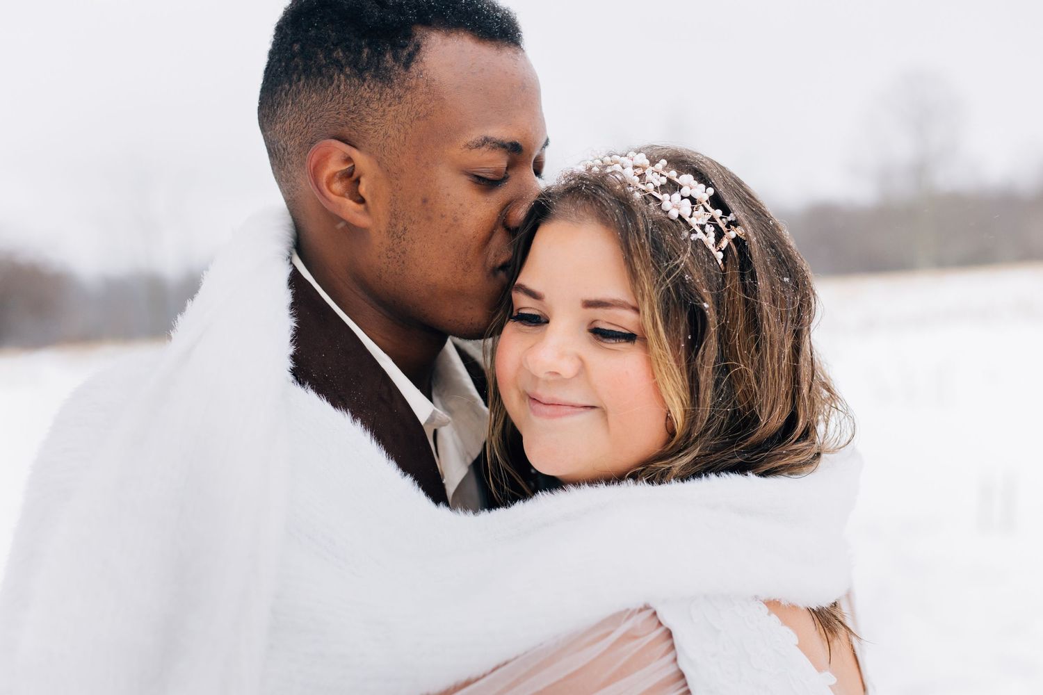 A winter wedding couple shares intimate moments against a white background.