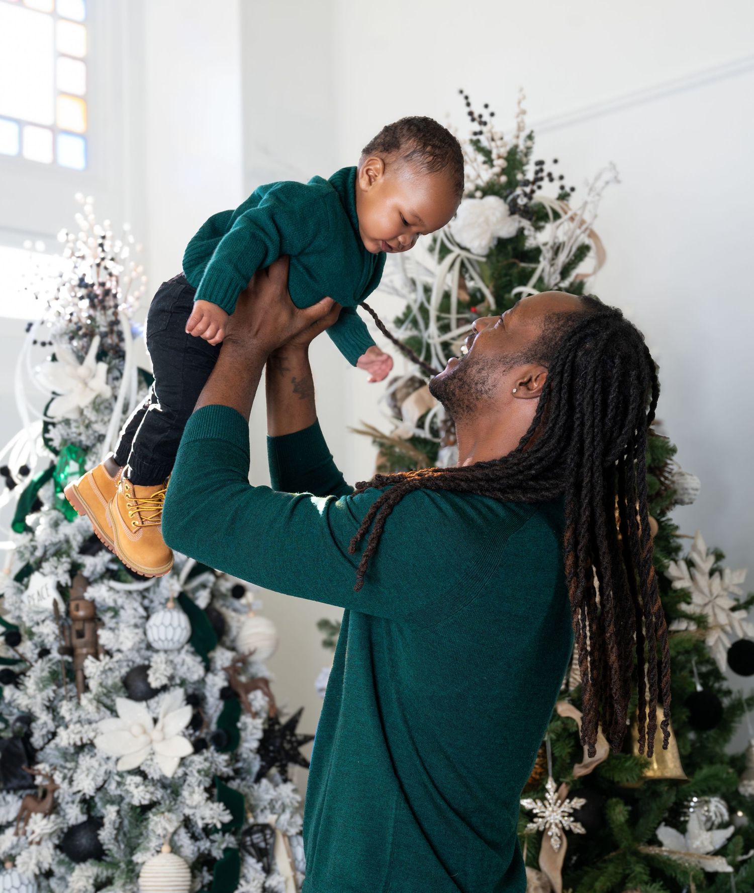 Joyful Christmas portrait by decorated tree with snowflake ornaments and holiday decorations.