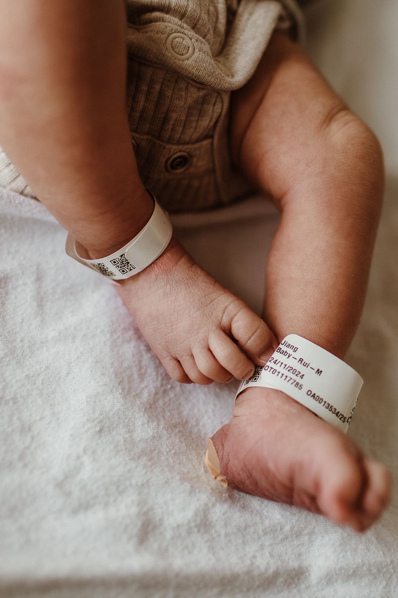 Close-up of tiny newborn feet with hospital identification band.