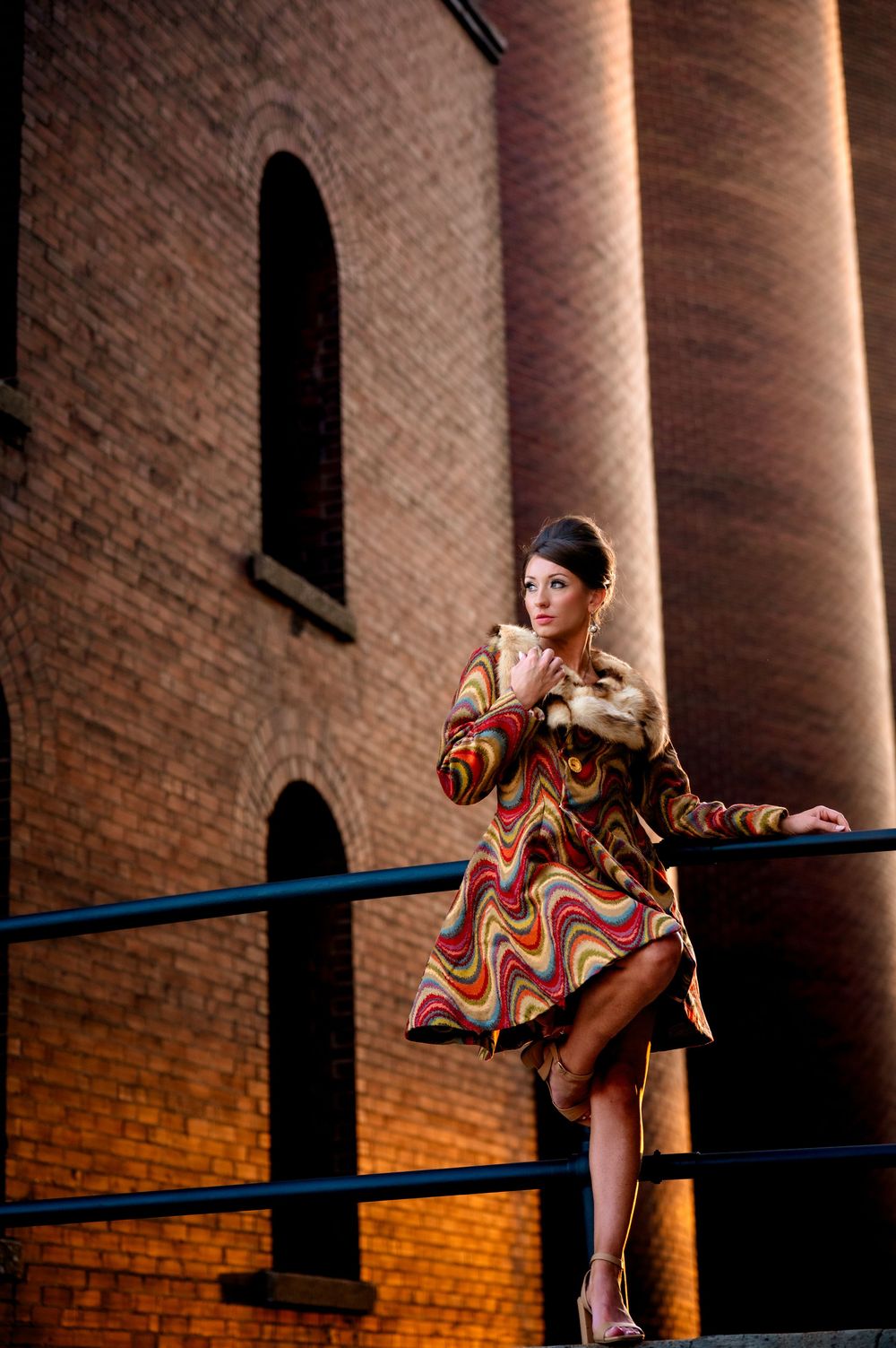 Graceful dancer in sequined dress strikes dynamic poses against brick wall with dramatic lighting and columns.