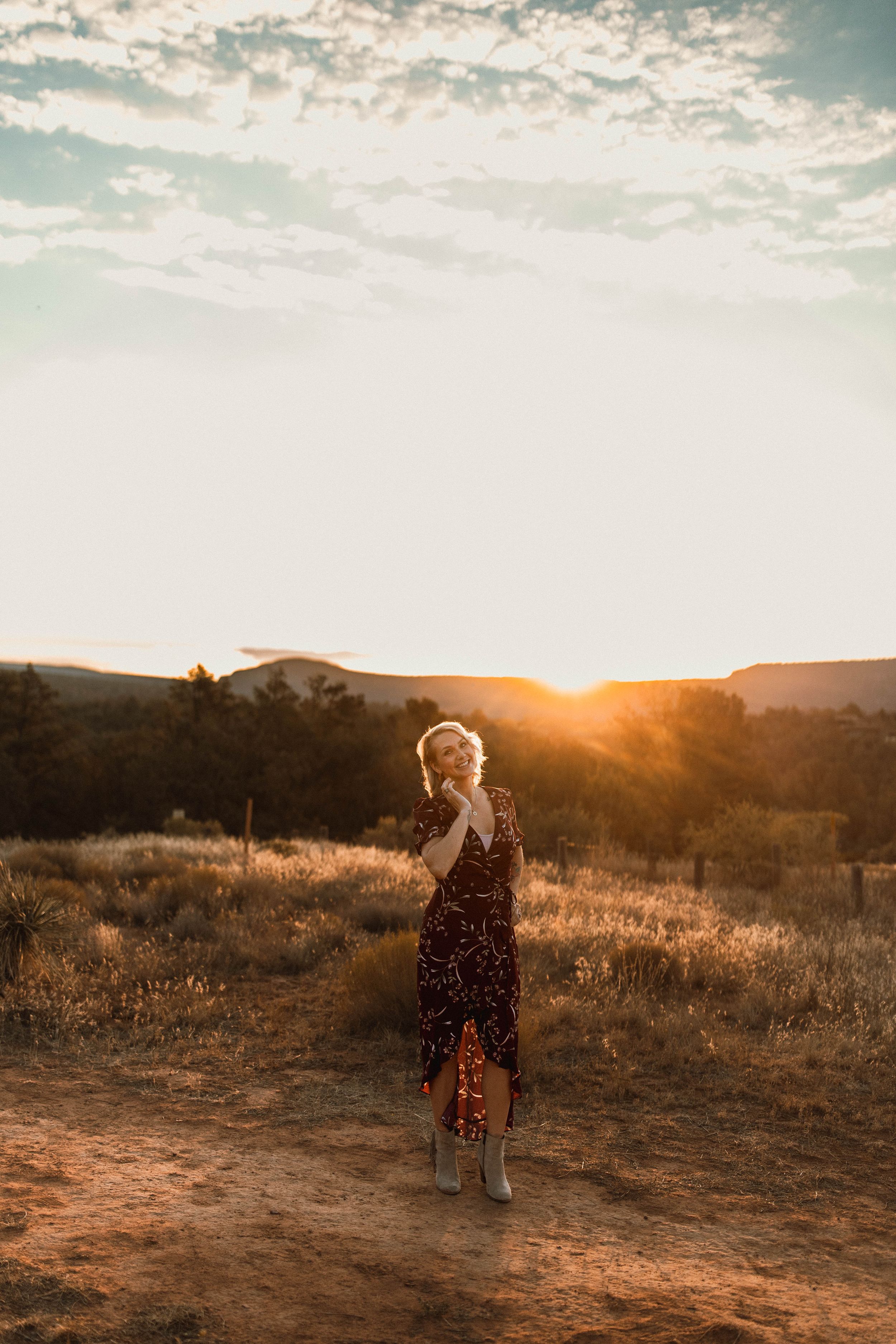 Silhouette of figure in flowy dress during golden hour in desert landscape.