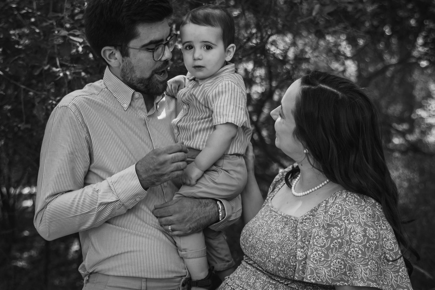 a mother and father look at their young son.