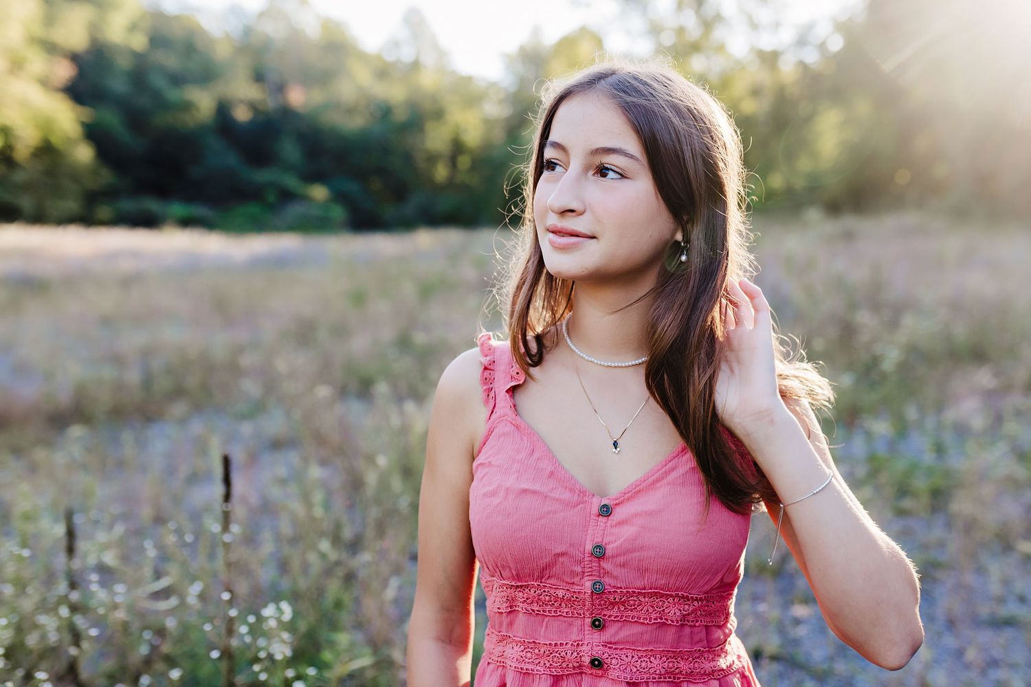 Teenage girl wearing a pink outfit for her senior photos