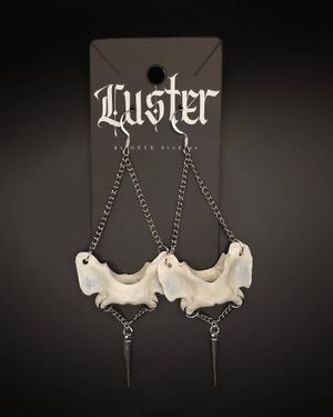 Gothic chain earrings with white skull elements and spike details on display card.