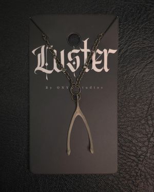 Gothic style wishbone necklace pendant displayed on black branded card.