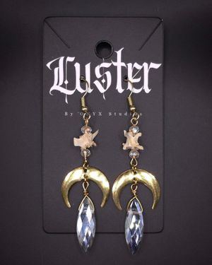 Crystal drop earrings with golden crescent moons and small bone charms.