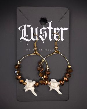 Hoop earrings decorated with brown crystal beads and small bone fragments.