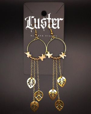 Gold hoop earrings with stars and cascading leaf charms on chains.