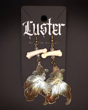 Vintage-style earrings with bone fragments and large brass feather charms.