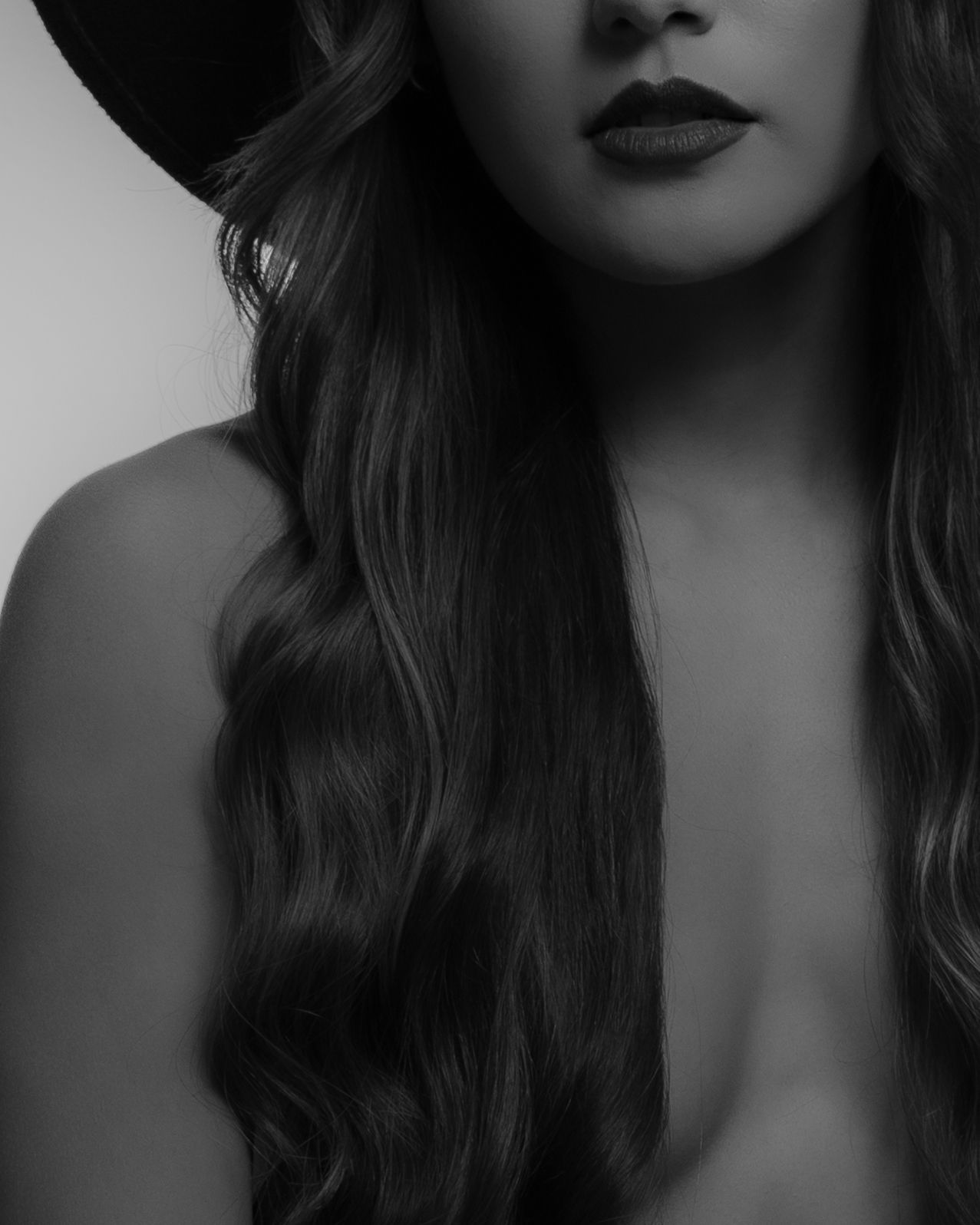 Gabriela Leal. Artistic black and white portrait showing long wavy hair and dark lipstick.