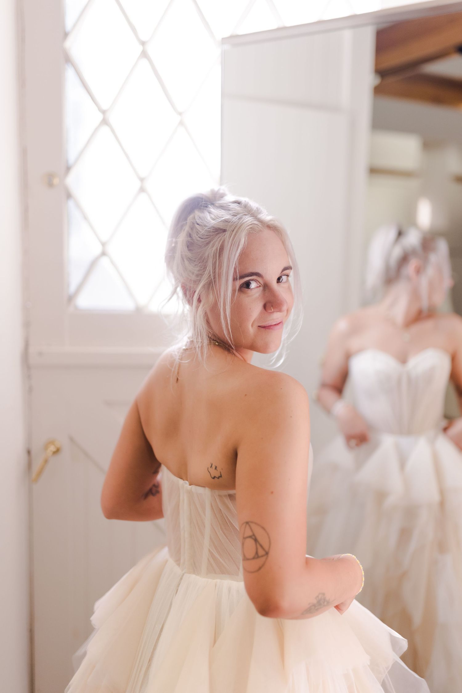 Four sequential shots of a woman in a strapless wedding dress posing playfully in a bridal boutique.