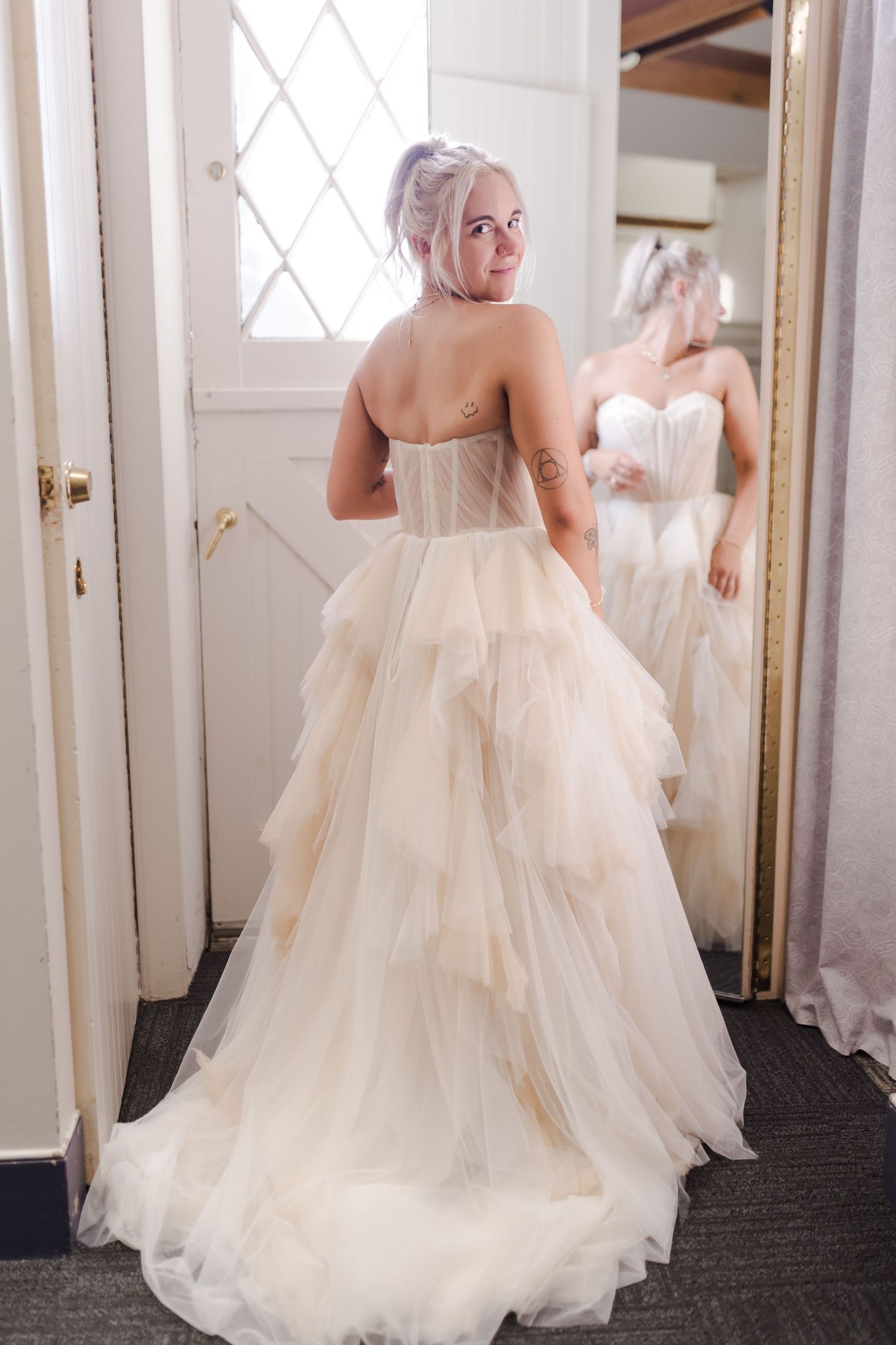 Four views of an elegant off-white tulle wedding gown with flowing skirt shown from different angles.