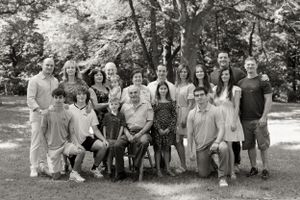 Large family group portrait gathered outdoors in casual attire.