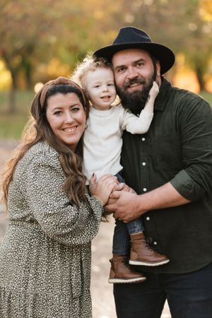 Family portrait in autumn light with coordinating outfits of dark green and animal print.