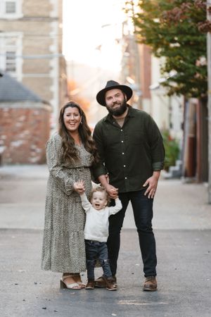 Urban family portrait on city street with coordinated casual outfits.