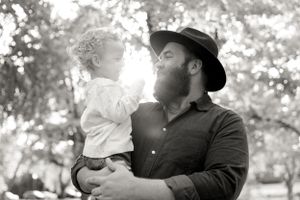 A black and white portrait showing a tender family moment.
