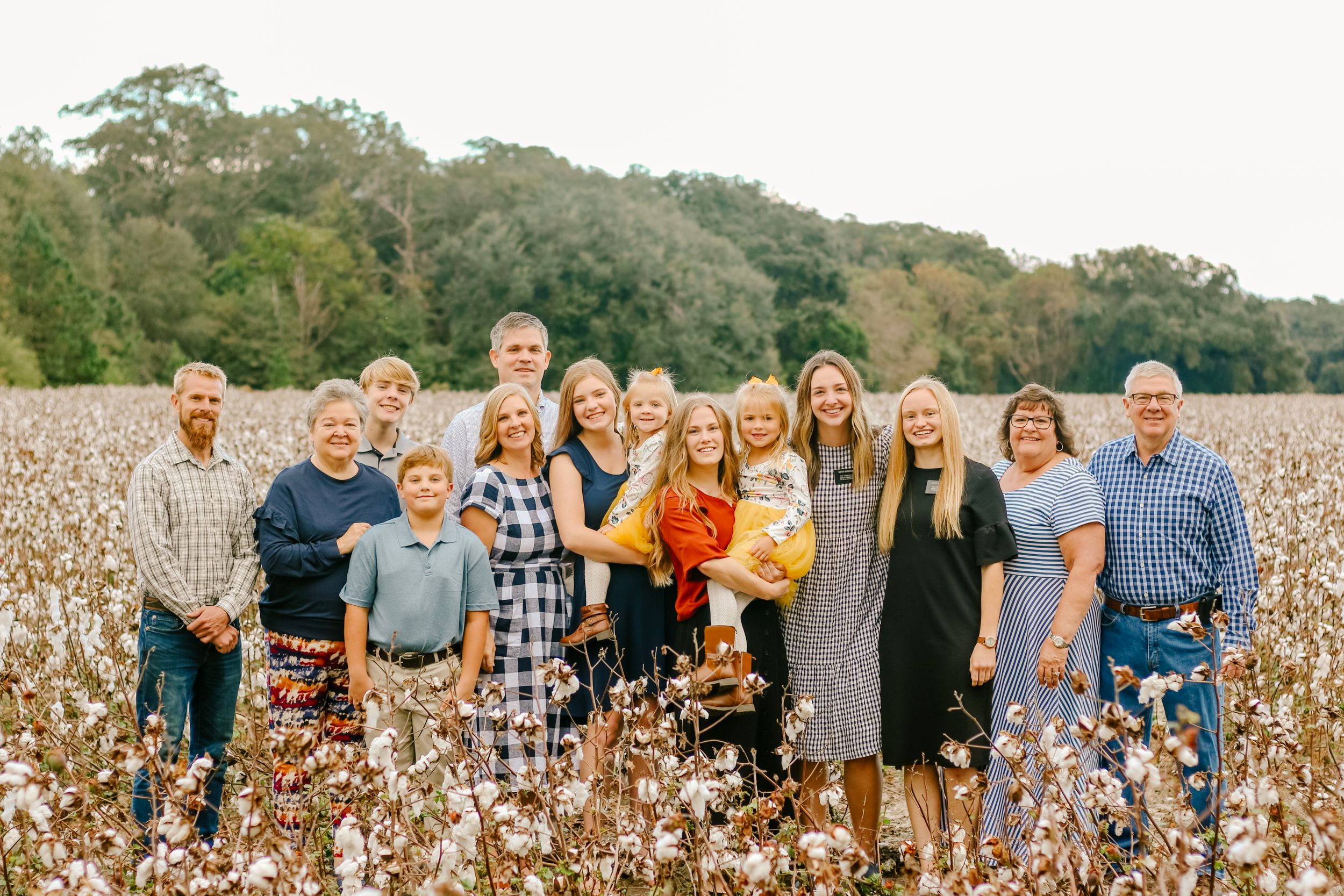Family portrait of multiple generations posed together in a cotton field.
