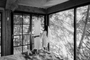 Panoramic view of a modern cabin with floor-to-ceiling windows and exposed wooden beams.