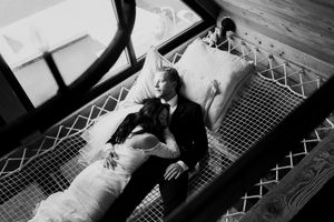 Black and white photograph of a tender moment in a rustic cabin interior.