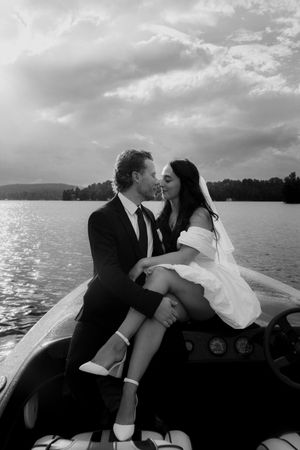 A romantic moment shared in a boat on a sunlit lake.