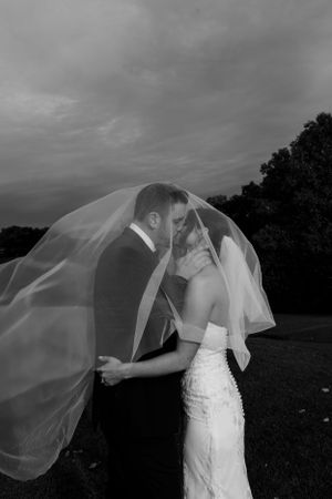 Dramatic black and white photo with flowing wedding veil in the wind.