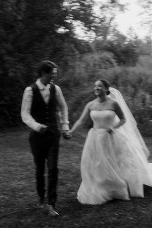 Candid black and white photo of people dancing and celebrating outdoors.