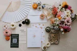Wedding stationery and floral decorations arranged with vintage paper fans.