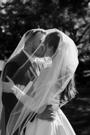 Intimate black and white wedding portraits captured through a delicate veil.