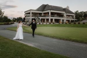Wedding venue exterior features elegant white columns and manicured grounds at sunset.