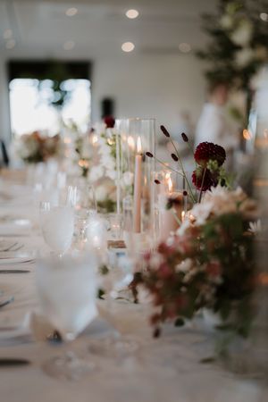 Dreamy wedding reception table settings with soft focus candles and floral arrangements.