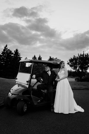 Black and white wedding photos with golf carts on a scenic course at dusk.