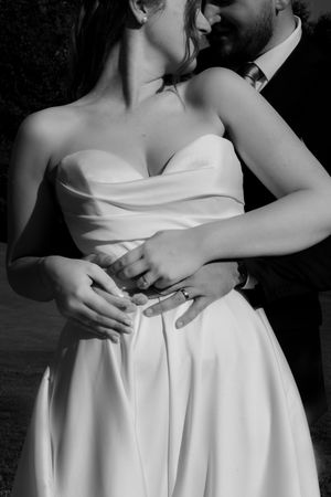 An intimate black and white wedding photo sequence featuring a bride in a strapless white gown.