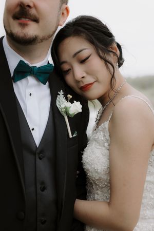 Close-up of couple in formal wedding attire sharing intimate moment.