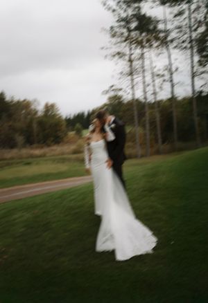 Motion blur wedding photo capturing couple dancing outdoors in natural setting.