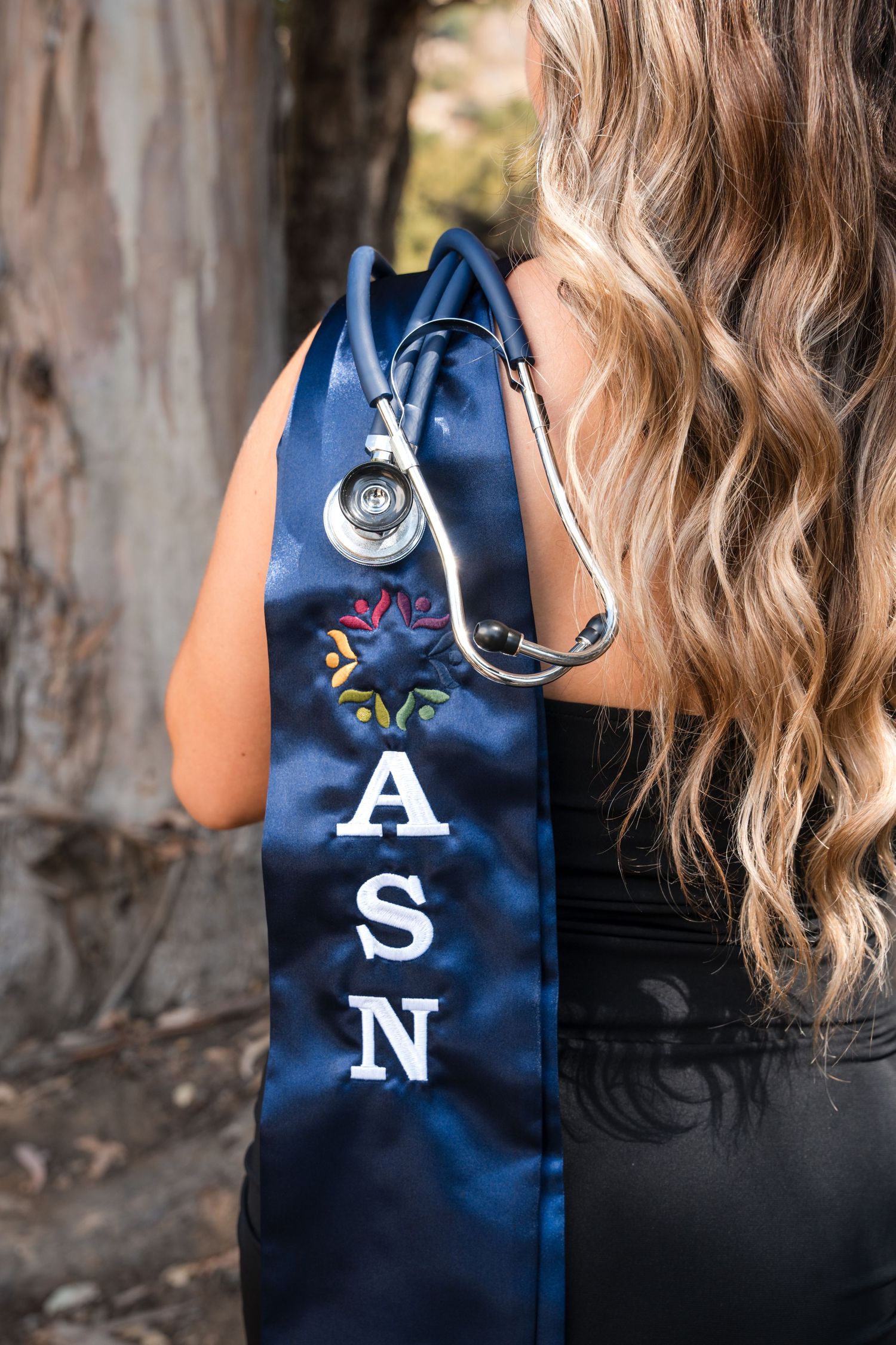 Navy blue ASN graduation stole with stethoscope detail against natural background.